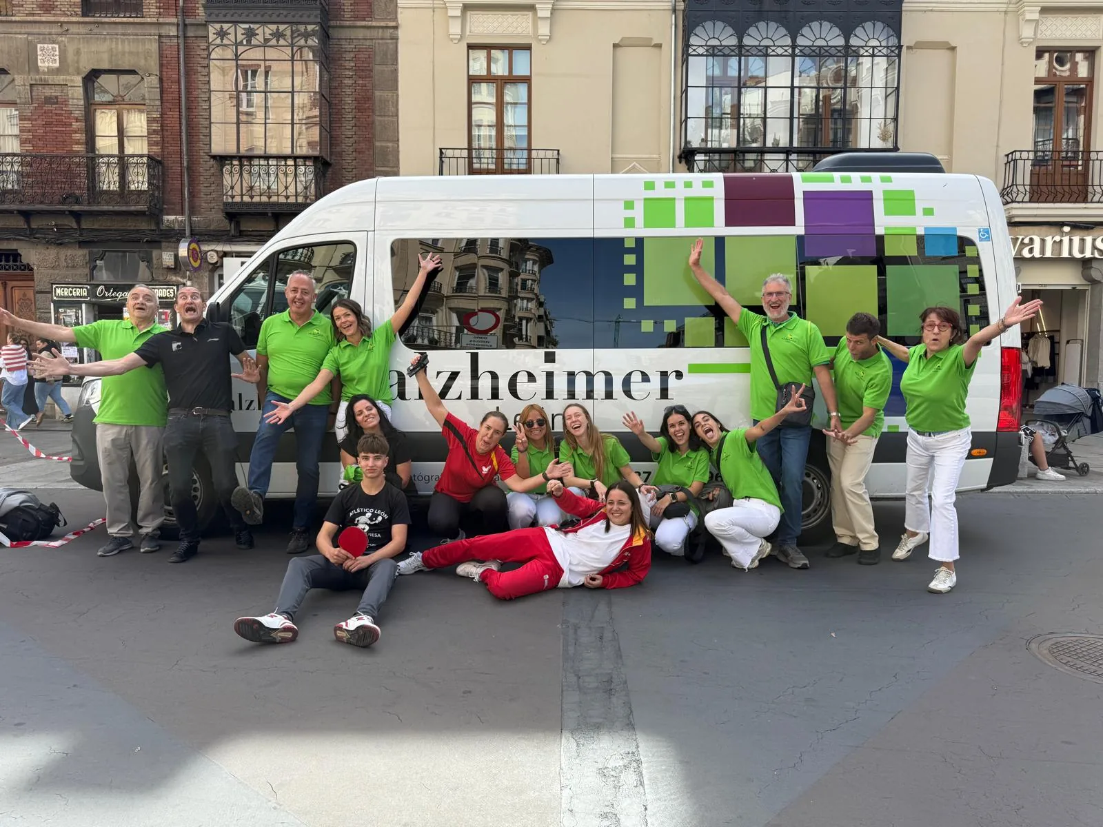 The Alzheimer León team celebrating in front of the association's minibus